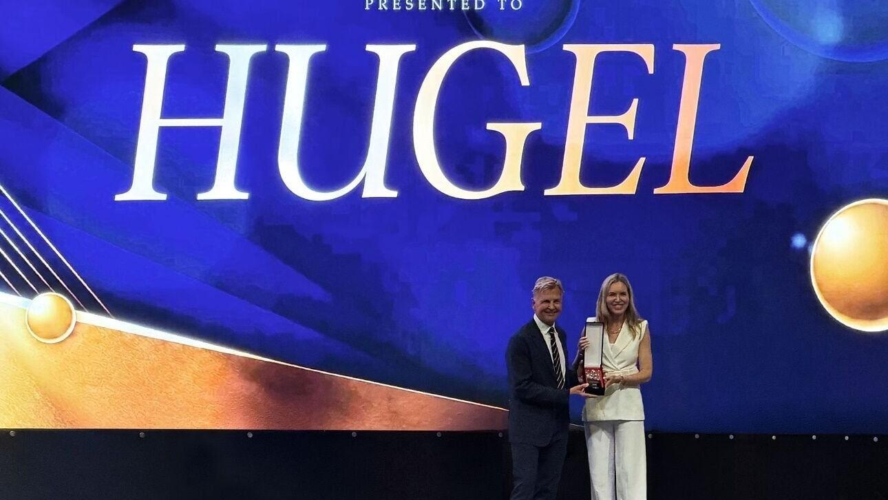 Carrie Strom, President and Global CEO of Hugel, receives the Best Injectables for Skin Anti-aging award at AMWC on June 19