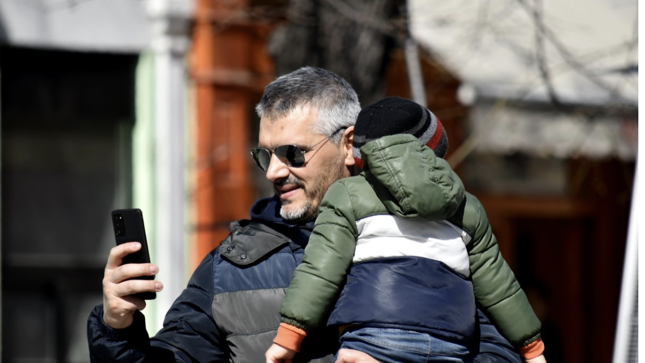 Man on Phone holding child