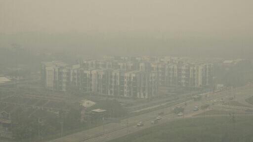 A photo taken from a commercial plane shows haze from Indonesian forest fires blanketing a residential district in Kuching, the capital city of Sarawak state on the island of Borneo on September 5