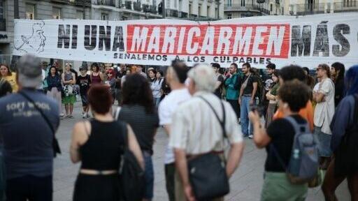 People gather next to a banner reading 'Not a single more Maricarmen' - in reference to an 87-year-old who was evicted