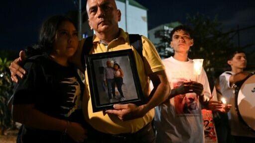 Carlos Zambrano holds a picture of his missing brother during a vigil honoring the victims of the Colombian earthquake