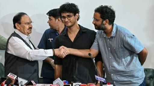 Cockroach Janta Party (CJP) spokespersons Ashutosh Ranka (R) and Saurav Das (C) greet India's Health Minister JP Nadda