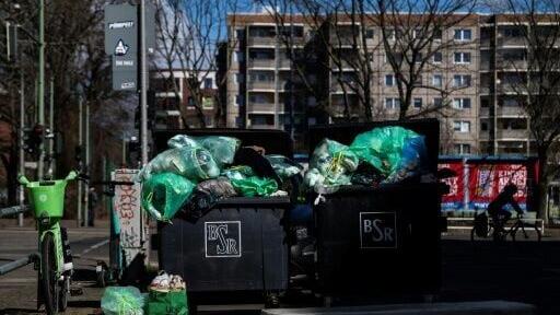 Overflowing garbage containers outside a Berlin residential building in March 2025 following a week-long warning strike by the city's waste management service