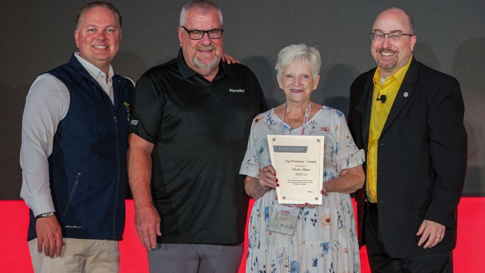 PostNet's Central Region Center of the Year winner for 2026 is its Draper, Utah location owned by Linda Schiele, who was honored at the company's annual conference in Chattanooga, Tenn. in July 2026. Pictured (from left) are Chief Commercial Officer and...