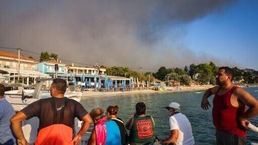 Small boats evacuated hundreds of tourists from beaches in northern Greece as fire threatened two popular resorts