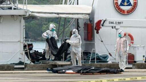 Philippine Coast Guard personnel unload body bags of victims of the ferry fire
