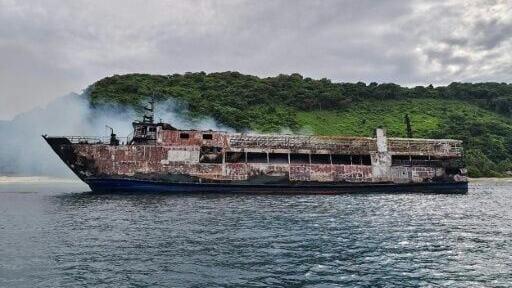 The M/V June Aster, which caught fire off the Philippine coast, is aground on an island in Palawan province