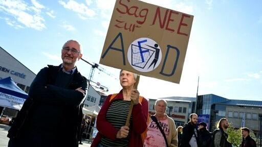 A woman holds an anti-AfD placard outide a meeting of the far-right party in the town of Neubrandenburg