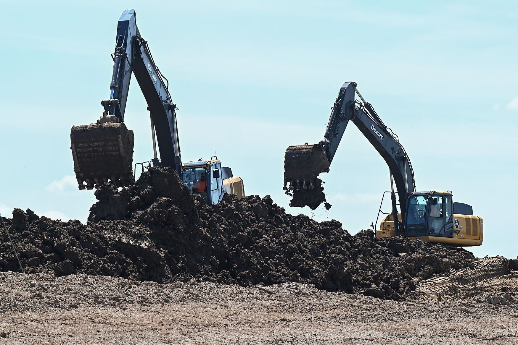 Two large excavators remove soil