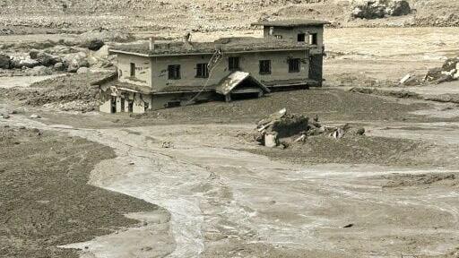 A house lies partially submerged in muddy water after flash floods at Trishuli Bazar in Nepal