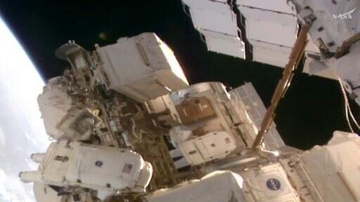 This frame grab from a NASA live video stream shows astronauts Anil Menon (L) and and Sophie Adenot (R) at the start of their spacewalk outside the International Space Station (ISS)