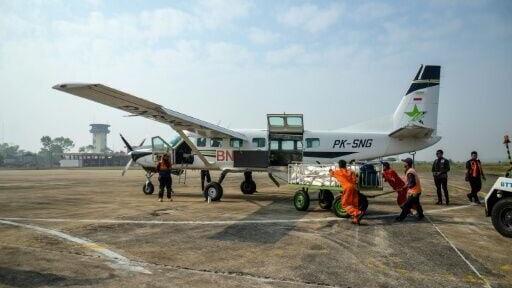 Personnel from the National Disaster Management Agency loading Sodium Chloride into an aircraft before a cloud seeding mission at Tjilik Riwut Airport in Palangka Raya, Central Kalimantan