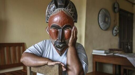 A woman deported from the US to Cameroon in an immigration crackdown shields her face with a mask as she poses for a photograph in Yaounde on September 9, 2026