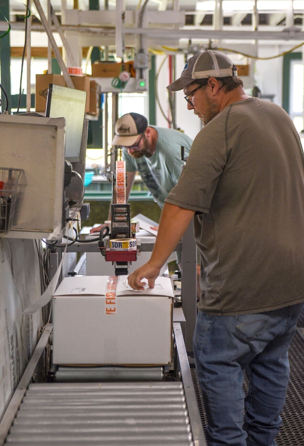 Michael Boure, back, and Peter Decker, front, seal boxes of live fish