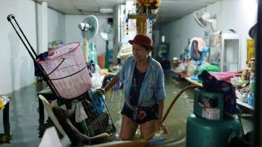 A person tends to their flooded shop in the Bang Bua district of Bangkok on September 26, 2026.