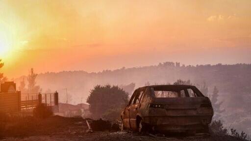 A burnt car is seen after a wildfire near the village of Siviri, northern Greece