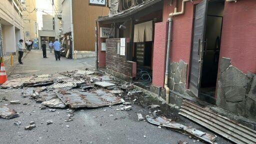 The exterior wall of a shop is seen collapsed in an earthquake, in Kumamoto City on July 28, 2026.
