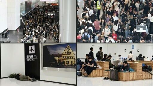 Passengers line up to enter the train station at Narita International Airport after rain caused transport chaos