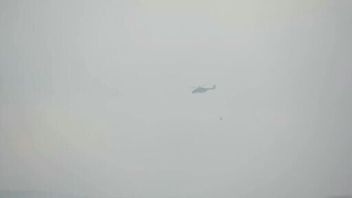 Helicopters carrying water above the smouldering landscape in Baelen as Belgium battles its worst wildfire in a century