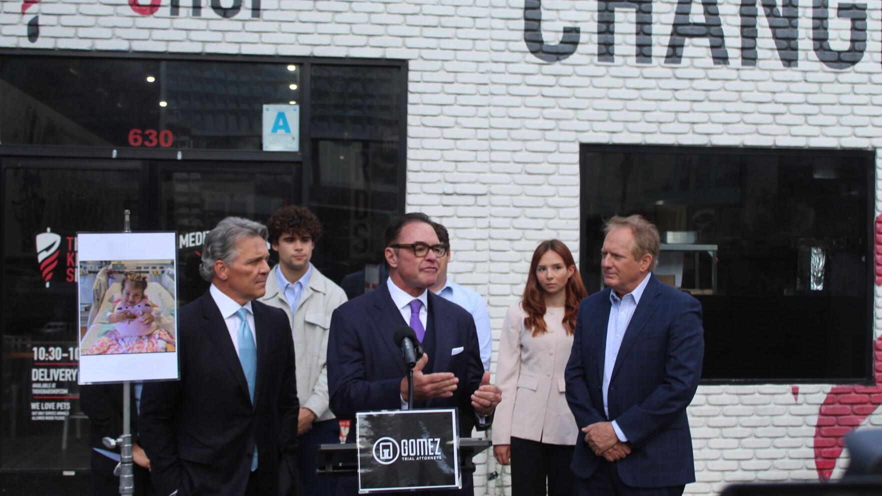National civil rights trial attorney John Gomez addresses members of the media during a May 28, 2026 news conference outside The Kebab Shop in downtown San Diego announcing the first lawsuit filed in connection with the ongoing E. coli outbreak. Standin...