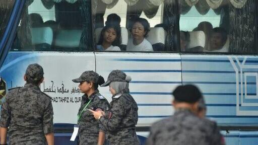 A bus carrying Myanmar nationals being repatriated from Malaysia to their homeland, is seen heading toward to navel base in Lumut, on the outskirts of Kuala Lumpur