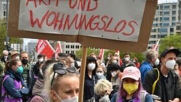 A protester holds a sign reading 'Poor but Sexy now is Poor and Homeless' during a rally against soaring rents in Berlin