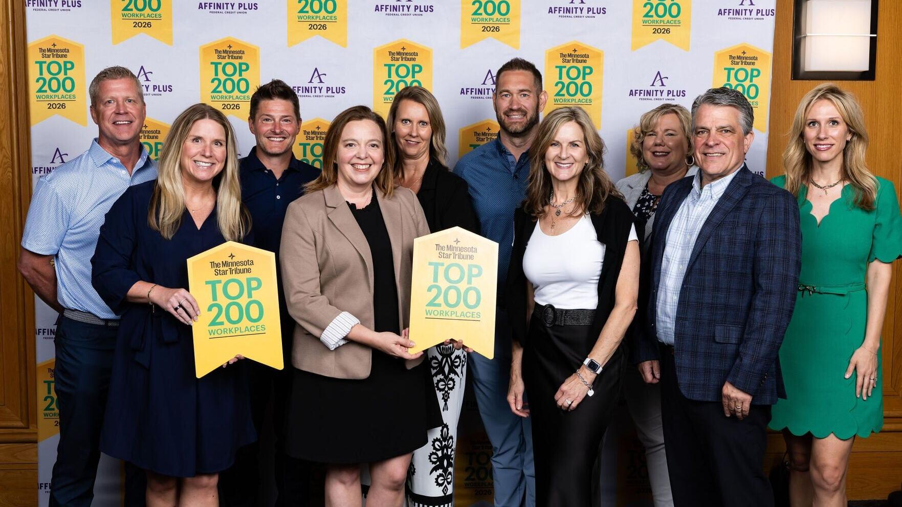 Luminate Bank’s leadership team accepts the Star Tribune Top Workplaces award. Pictured, front row, left to right: Courtney Hoefener, Leah Burak, Debbie Schwake, and Marc Campbell. Back row, left to right: Matt Criego, Nate Raich, Stacy Greven, Taryn Re...