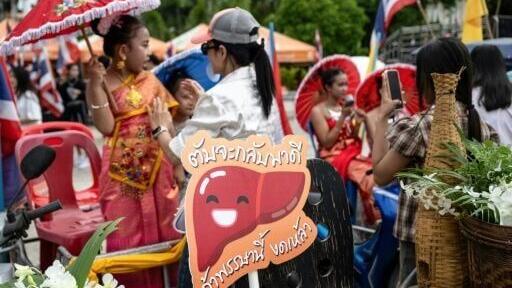 A sign with a happy liver is seen during a parade to encourage people to abstain from drinking alcohol for three months at the start of Buddhist Lent