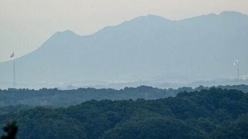 National flags of South Korea (R) and North Korea (L) are seen within the Demilitarized Zone (DMZ) dividing the two Koreas, from Paju on September 12, 2026