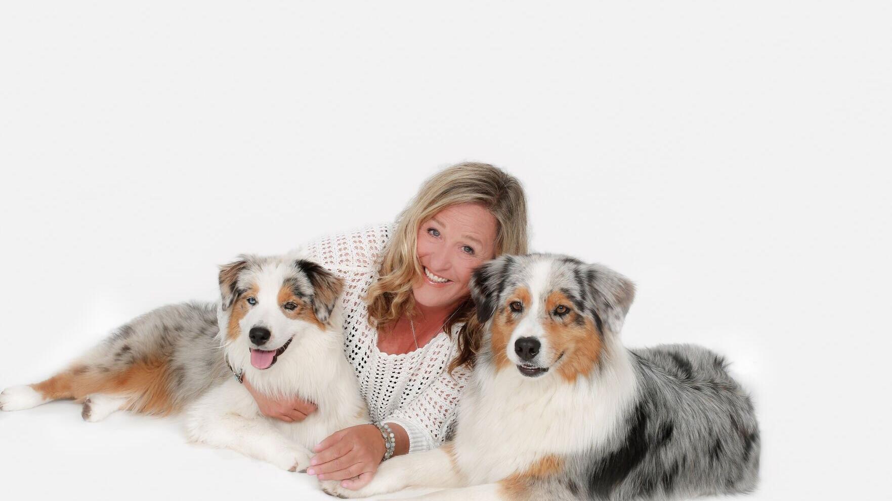 Award-winning writer, therapy dog trainer, evaluator, and volunteer Susan Hartzler with her Australian Shepherd therapy dogs, Seven and Paige Turner. Hartzler's new book, Teaming Up with Therapy Dogs: Skills to Build Healing Partnerships, provides pract...