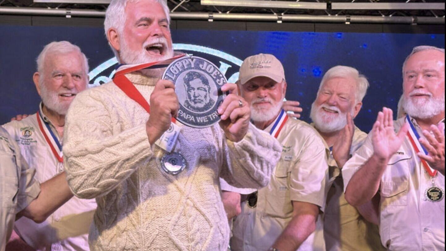 Tim Stockwell, winner of the 2025 Hemingway Look-Alike Contest in Key West, Fla., raises his winners' medal and grins triumphantly as other look-alikes congratulate him. The 2026 Hemingway Look-Alike Contest and festival is scheduled July 21-26, headqua...