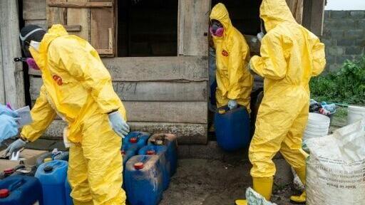 Officers from Nigeria's National Drug Law Enforcement Agency (NDLEA) examine chemicals found in the meth lab in Iroto, Ogun State in May
