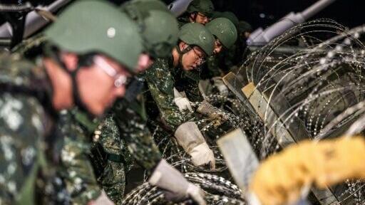 Taiwanese soldiers deploy concertina wire barriers during a blockade drill held as part of the annual Han Kuang military exercise, in New Taipei City