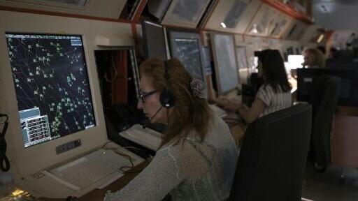 An air traffic controller handles a full radar screen at the Greek Civil Aviation Authority in Athens