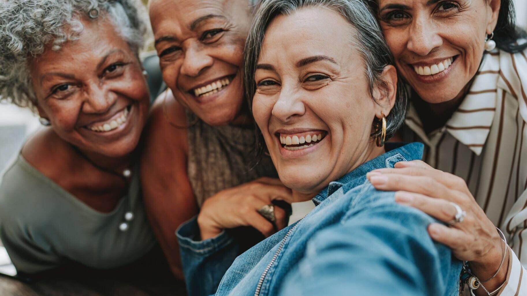 Adult women aged 55 and better smile and share companionship.