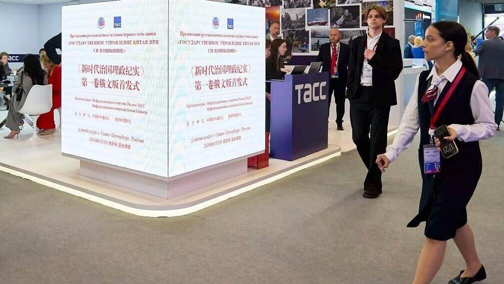 People walk past screens displaying information of the launch ceremony of the Russian edition of the first volume of "China's Governance Under Xi Jinping's Leadership" at the 29th St. Petersburg International Economic Forum in St. Petersburg, Russia, Ju...