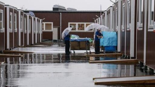 Cleaners enter a temporary container hut during a press tour in Nagoya