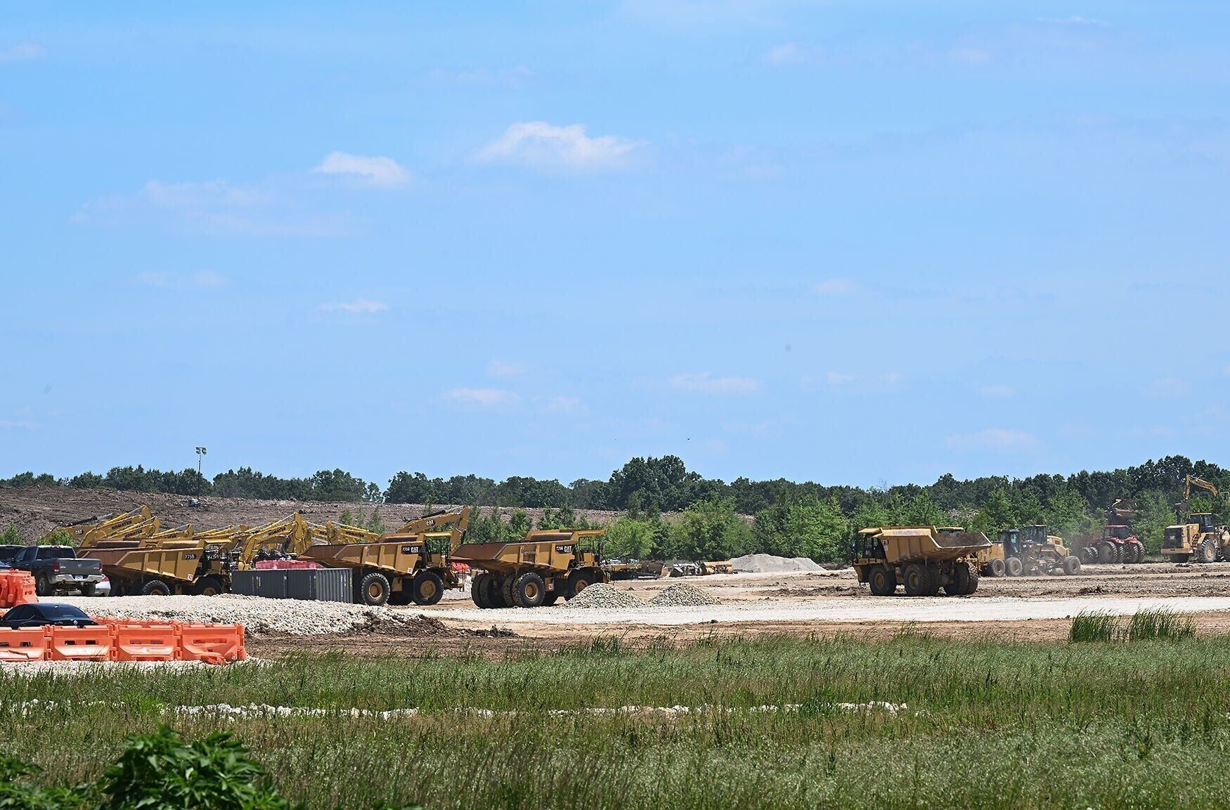 Large dump trucks traverse the construction site