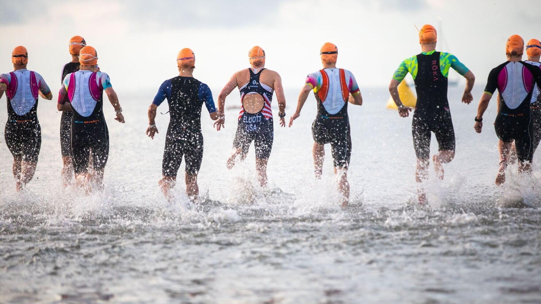 Several athletes run into the water to prepare for the swim leg of the 2026 St. Anthony’s Triathlon in April.