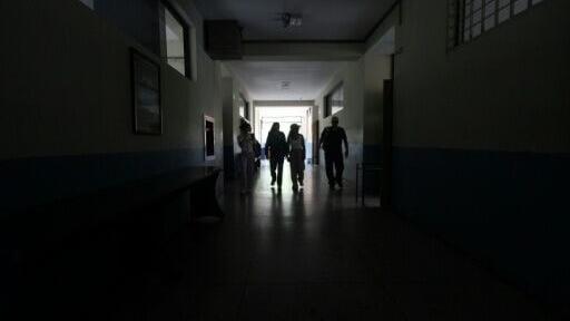 Students walk in a dark hallway at a university in San Cristobal, a city in Venezuela's Tachira state that experiences frequent power cuts