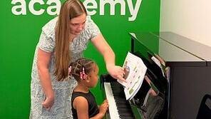 A Gramercy Music Academy instructor provides one-on-one piano instruction to a young student at the academy's Houston location.