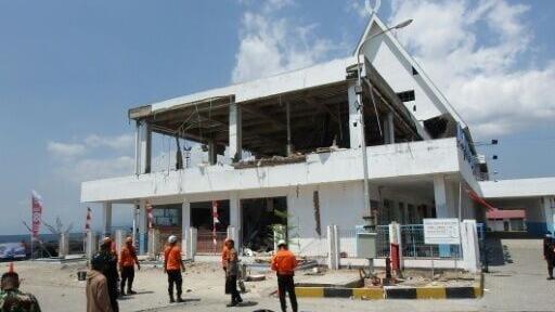 A rescue team searches for victims in the ruins of the Laurensius Say Port in Maumere, Indonesia