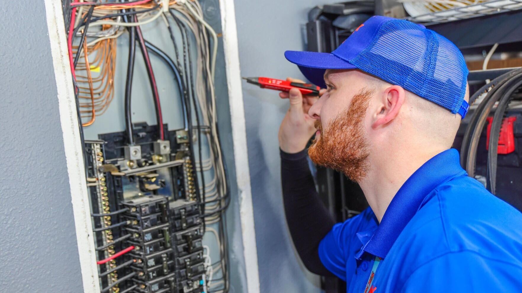 A Frank Gay Services technician inspects an electrical panel.