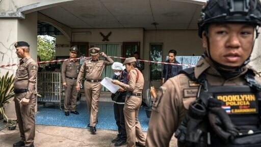 Police gather outside the house where a teenager is suspected of killing his grandparents before carrying out a school shooting north of Thailand's capital Bangkok.