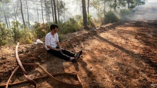 A volunteer rests amid operations to tackle a wildfire in Fethiye, southwest Turkey