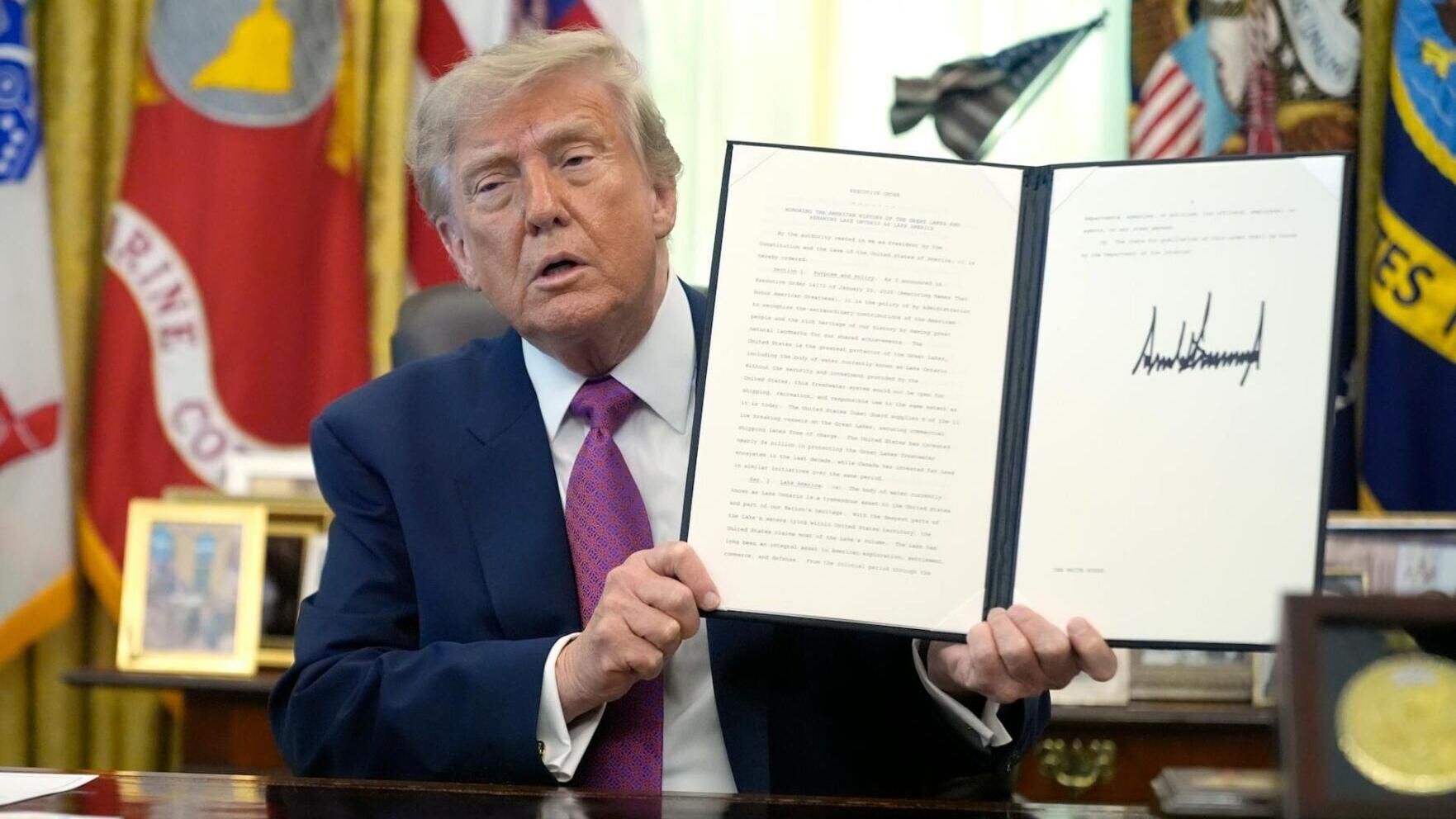 President Donald Trump holds up a signed executive order in the Oval Office in August 2026.