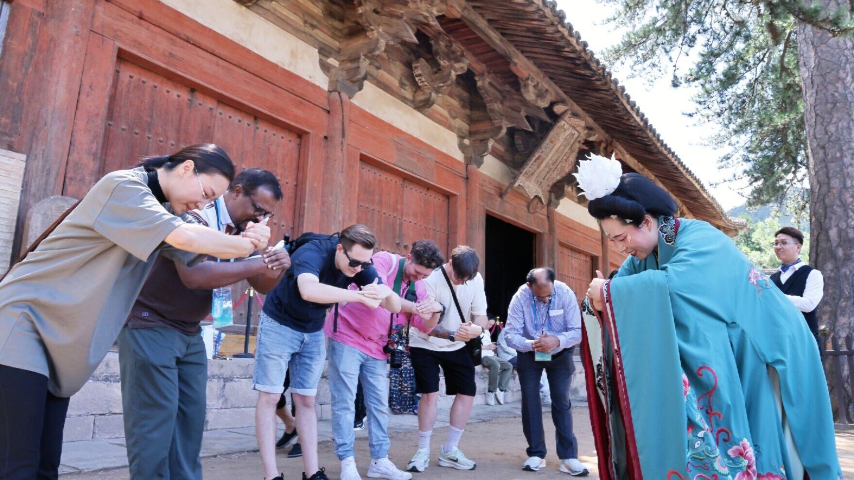 Guests on the “Discovering Shanxi’s Ancient Chinese Architecture” tour practice the Tang-style hand-over-chest salute at Foguang Temple in Xinzhou.
