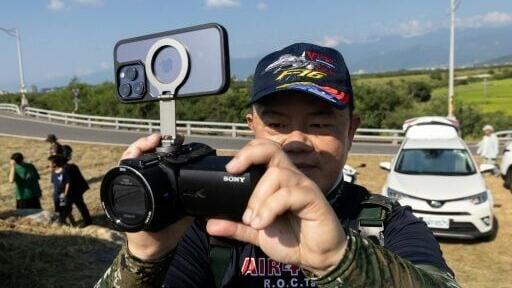 An aviation enthusiast waits outside Chihhang Air Base for the arrival of Taiwan's newly purchased F-16V fighter jets