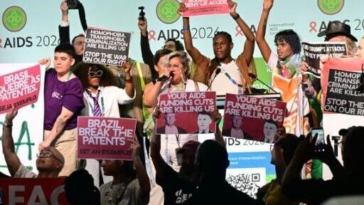 Protesters burst onto the stage at the opening of the 26th International AIDS Conference in Rio de Janeiro