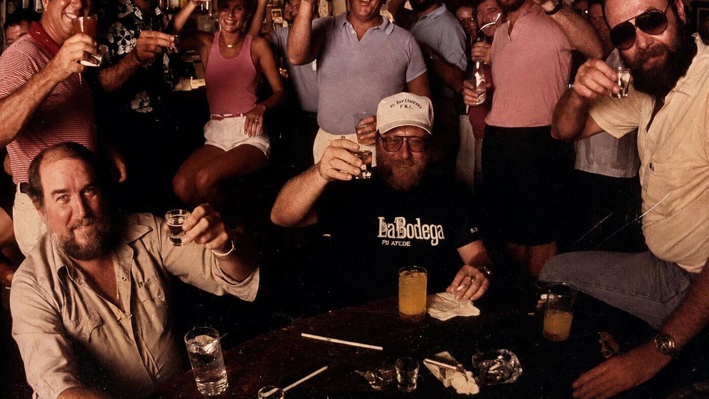 Legendary Chart Room bartender Phil Clark (far right) raises a toast with friends during 1980s. Clark's tales of smugglers, treasure hunters, sailors, and Caribbean adventures captivated a young Jimmy Buffett and later helped inspire one of Buffett's mo...